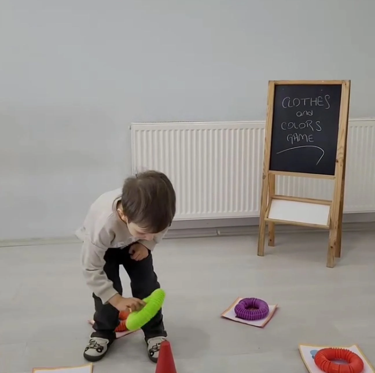 Renk eşleştirme oyununda halkaları doğru kartın üzerine koyan çocuk